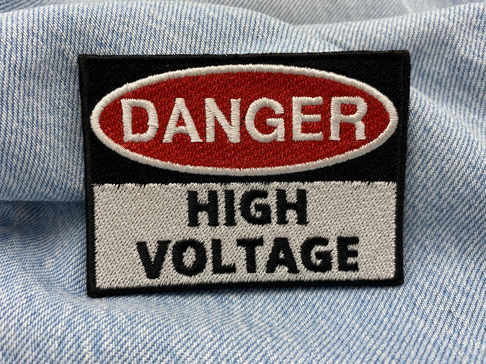 High Voltage Patch auf blauer Jeans 