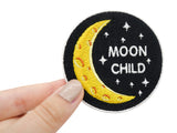 and einer Frau hält den Moonchild Aufbügelpatch.