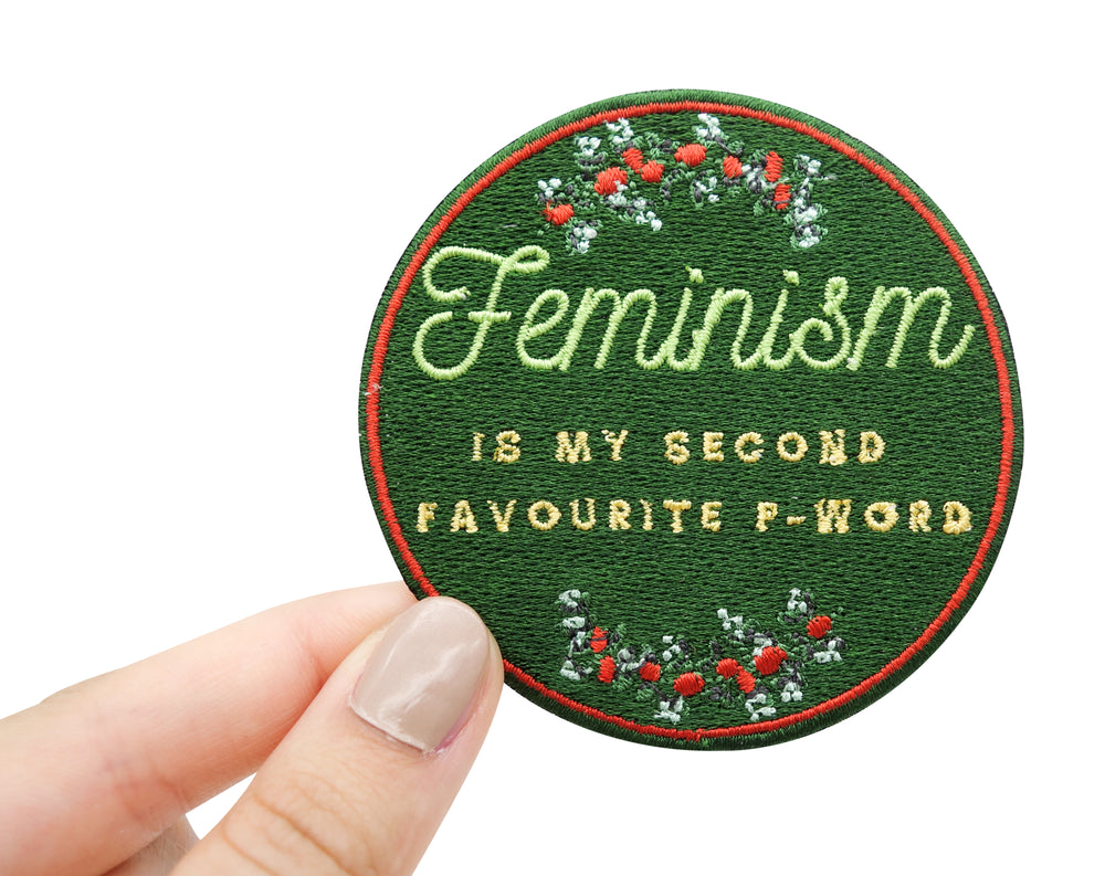 Frauenhand hält den Feminism Patch