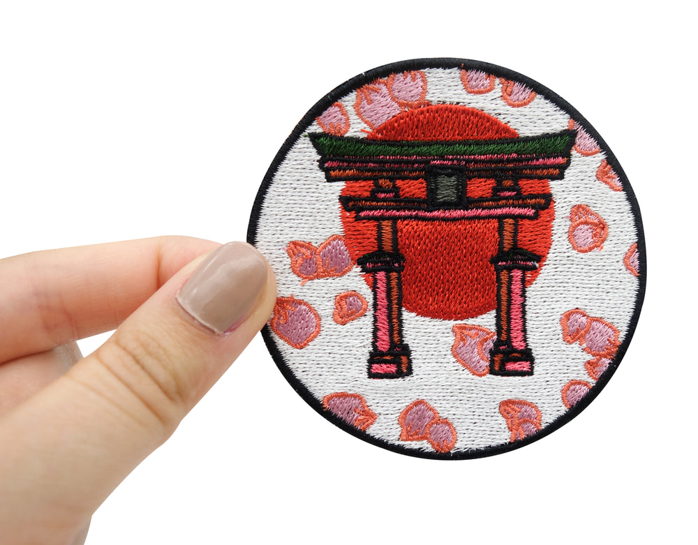 Japanisches Tor Patch gehalten von einer Frauenhand