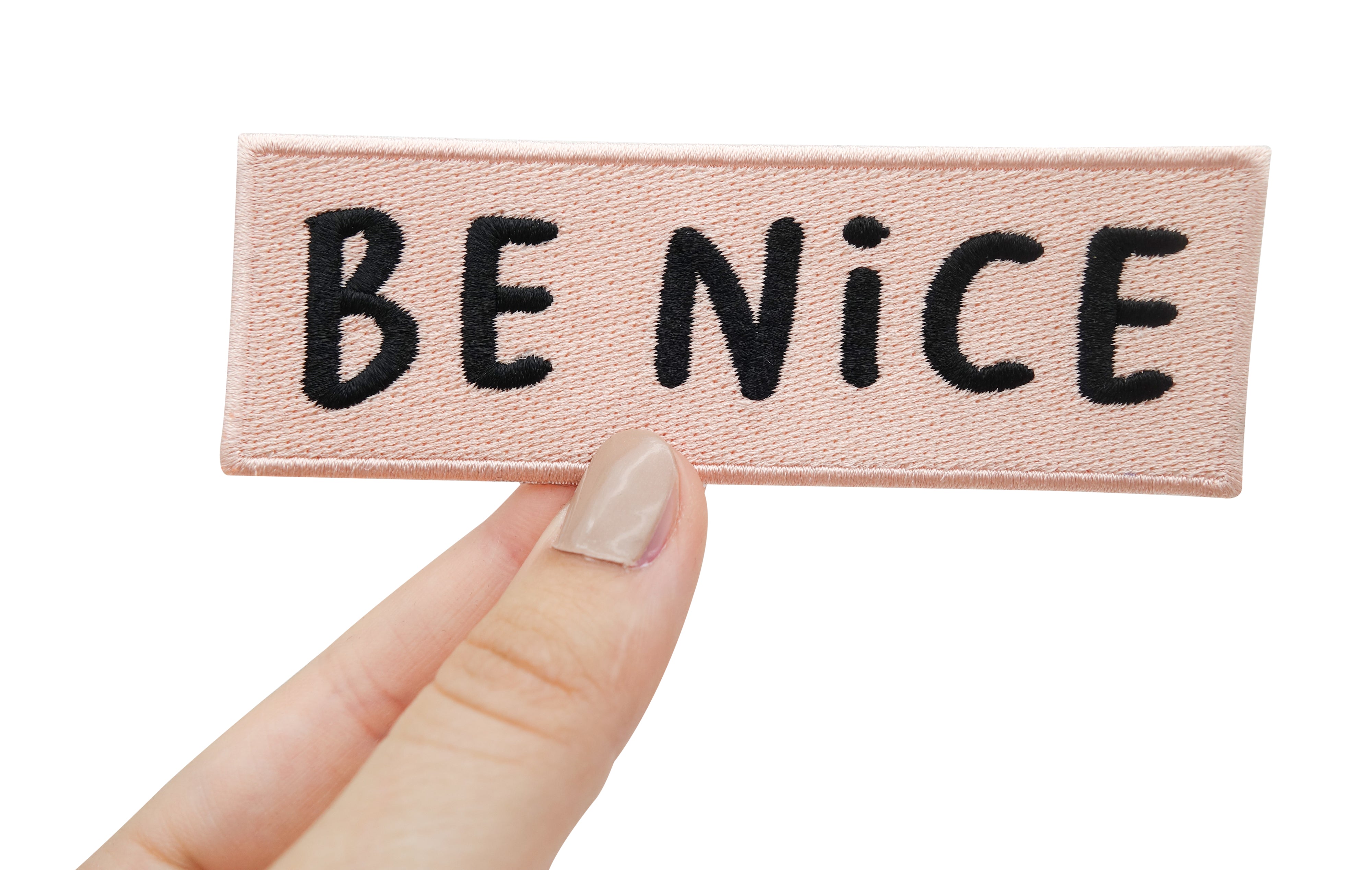 Frauenhand hält rosa Be Nice Patch