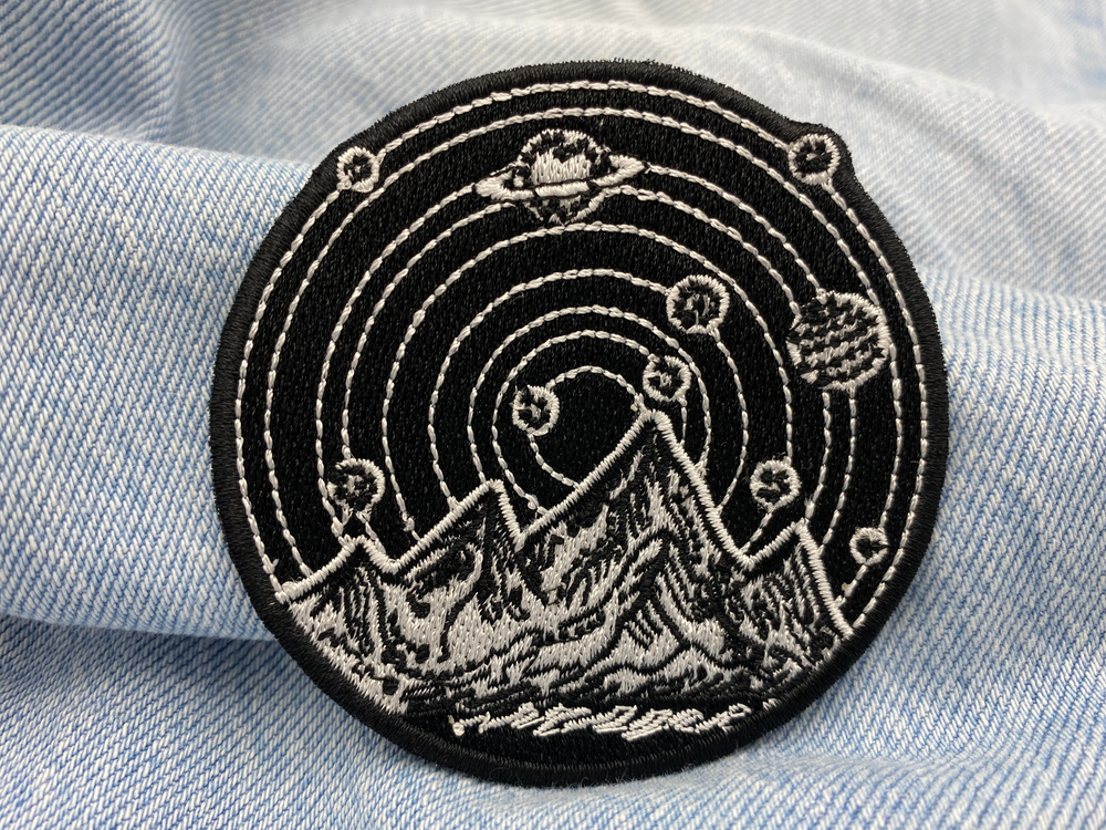 Berge mit Planeten Patch auf blauer Jeans