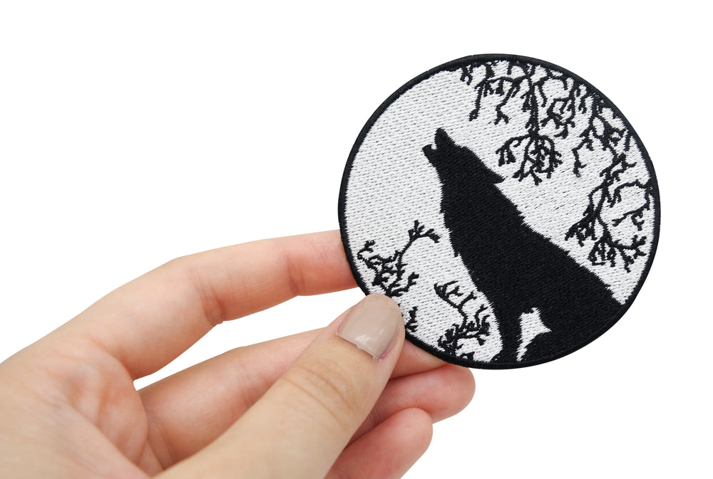 Frauenhand hält den Wolf Patch 