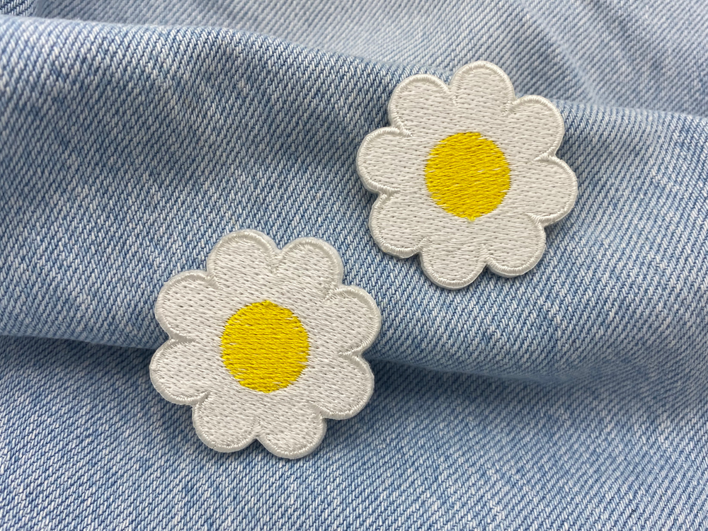 Gänseblumen Patches auf blauer Jeans