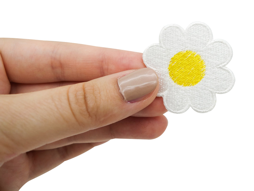 Frauenhand hält den Gänseblumen Patch 