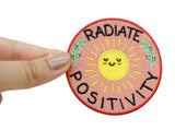 "Radiate Positivity" Patch gehalten von einer Frauenhand