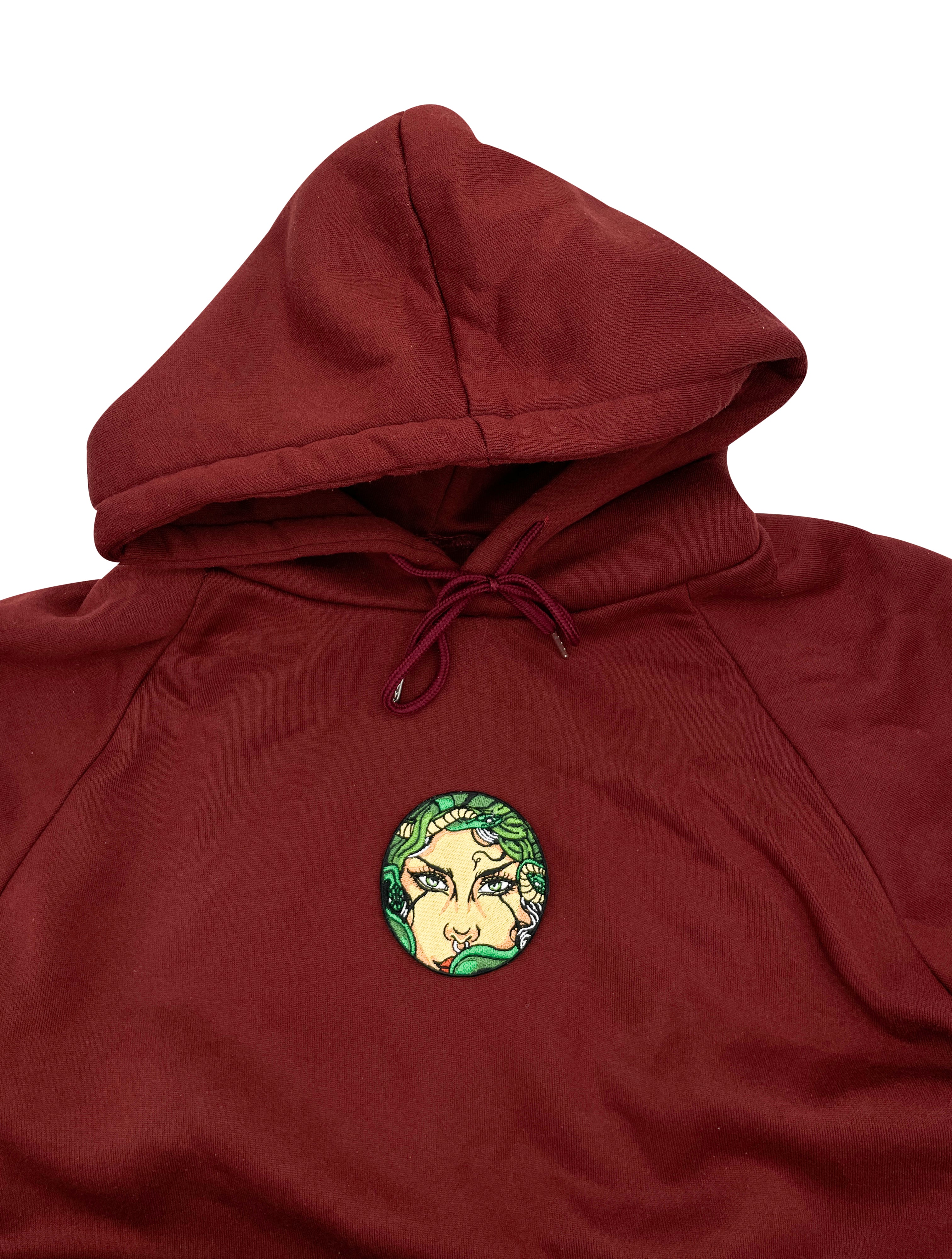 Medusa Patch auf rotem Pullover aufgebügelt