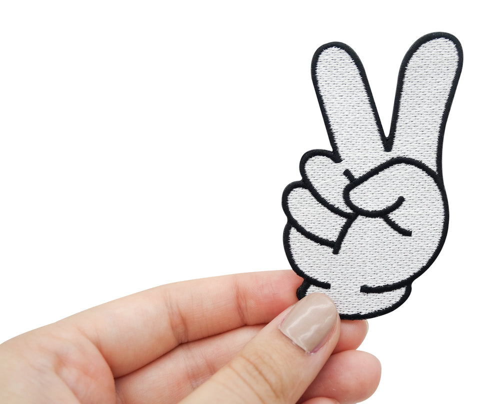 Frauenhand hält Cartoon Peace Zeichen Patch 