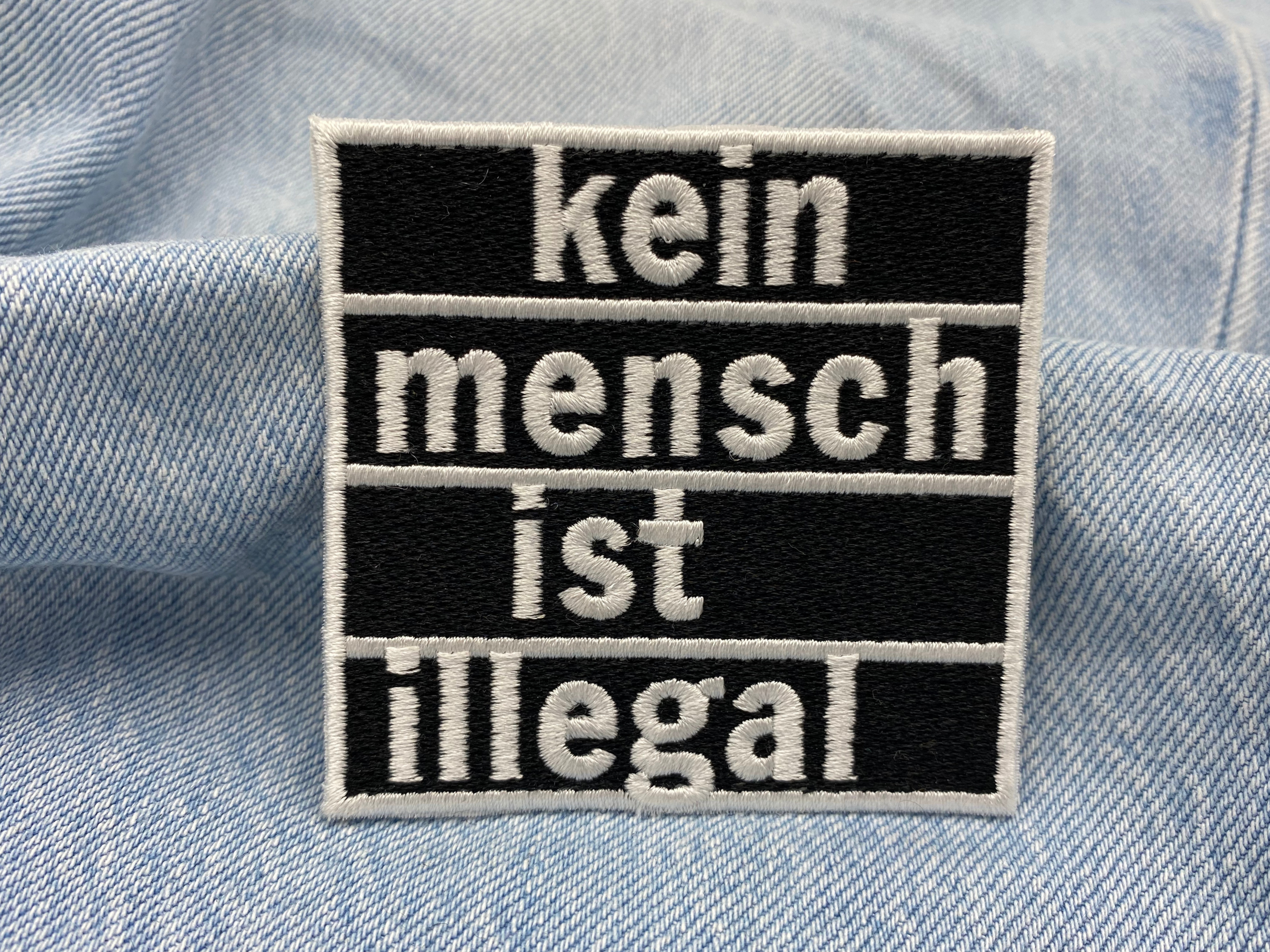 Statement Patch auf hell blauer Jeans