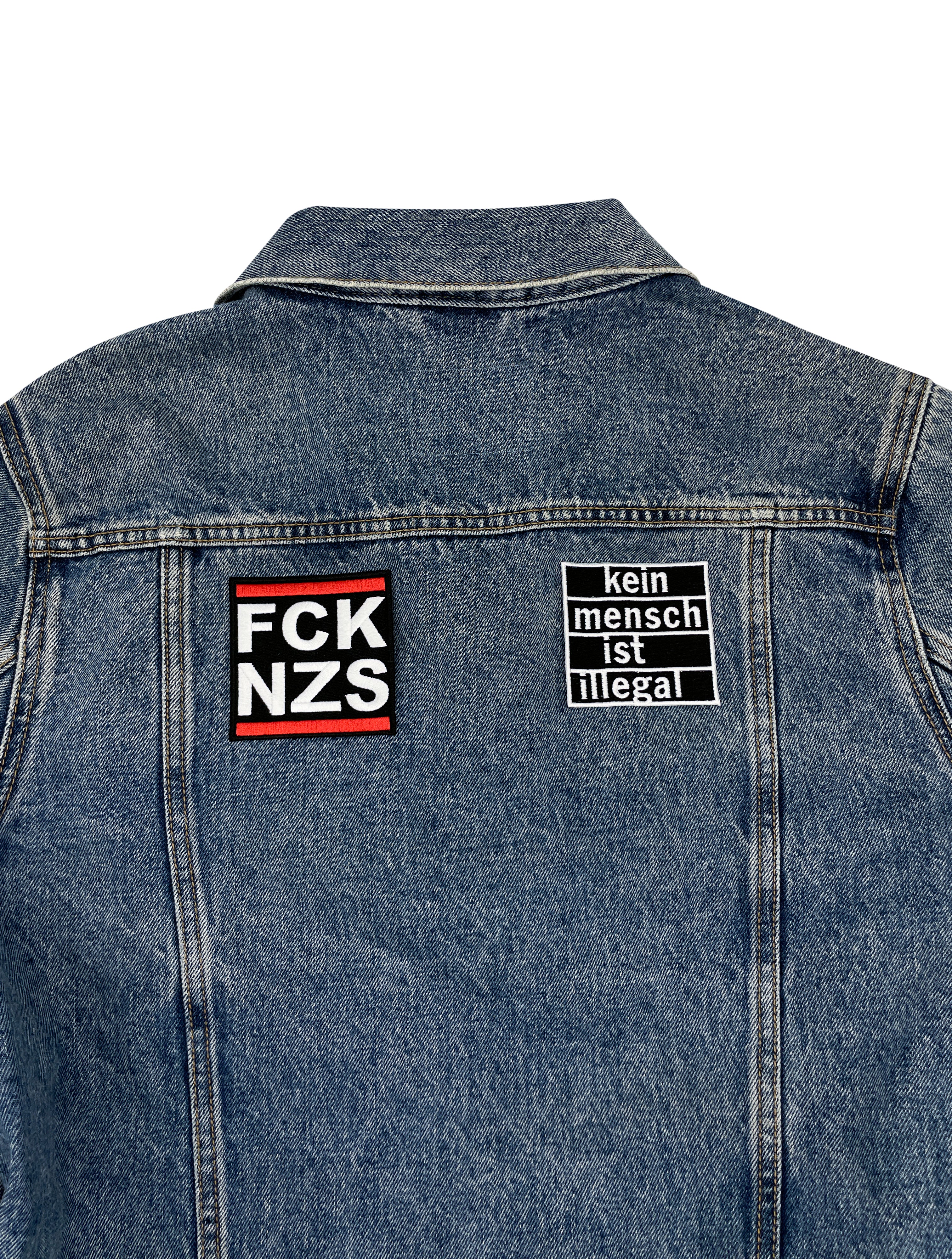Zwei Statement Patches auf Rückseite einer Jeansjacke aufgebügelt