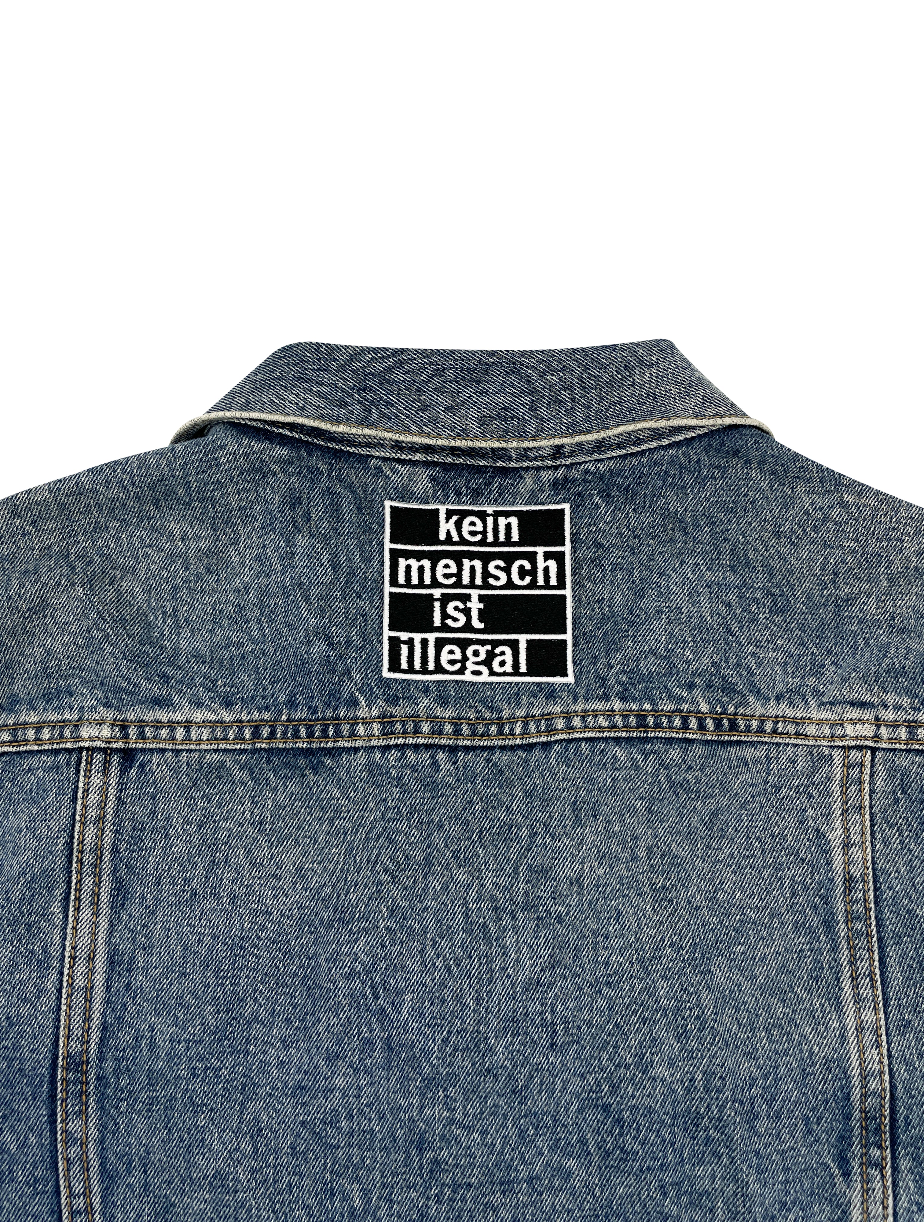 Statement Patch auf Rückseite einer Jeansjacke aufgebügelt