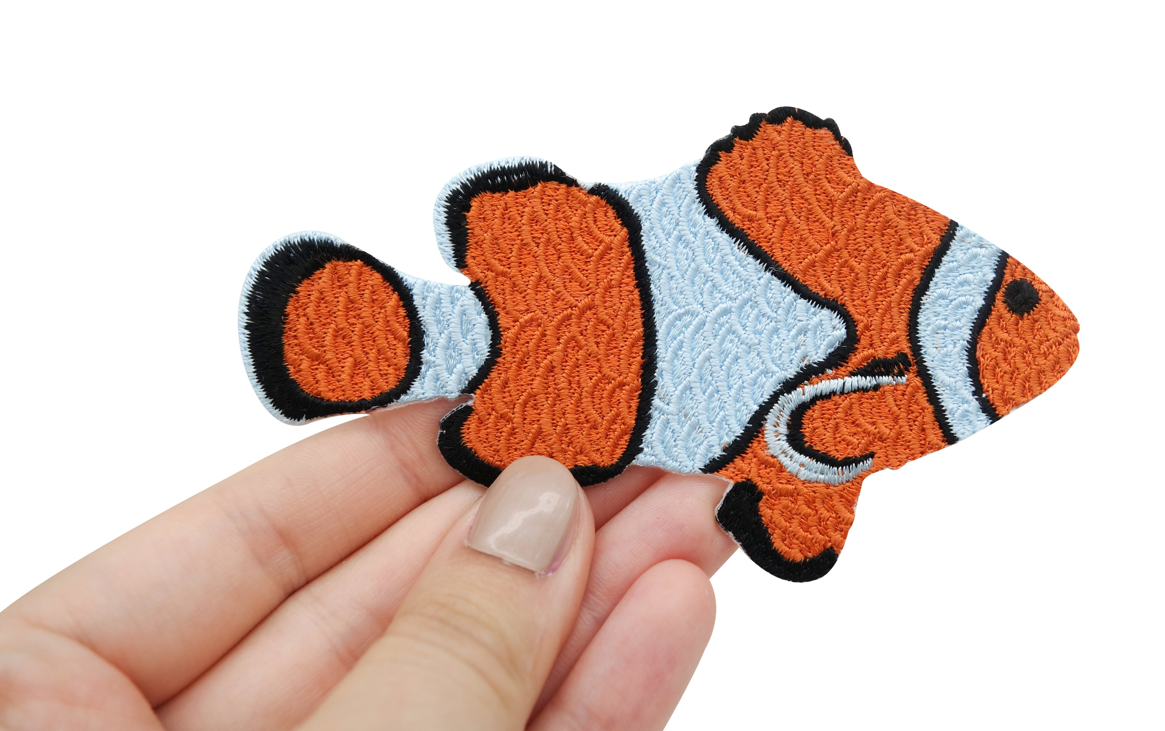 Clown Fisch Patch gehalten von einer Frauenhand