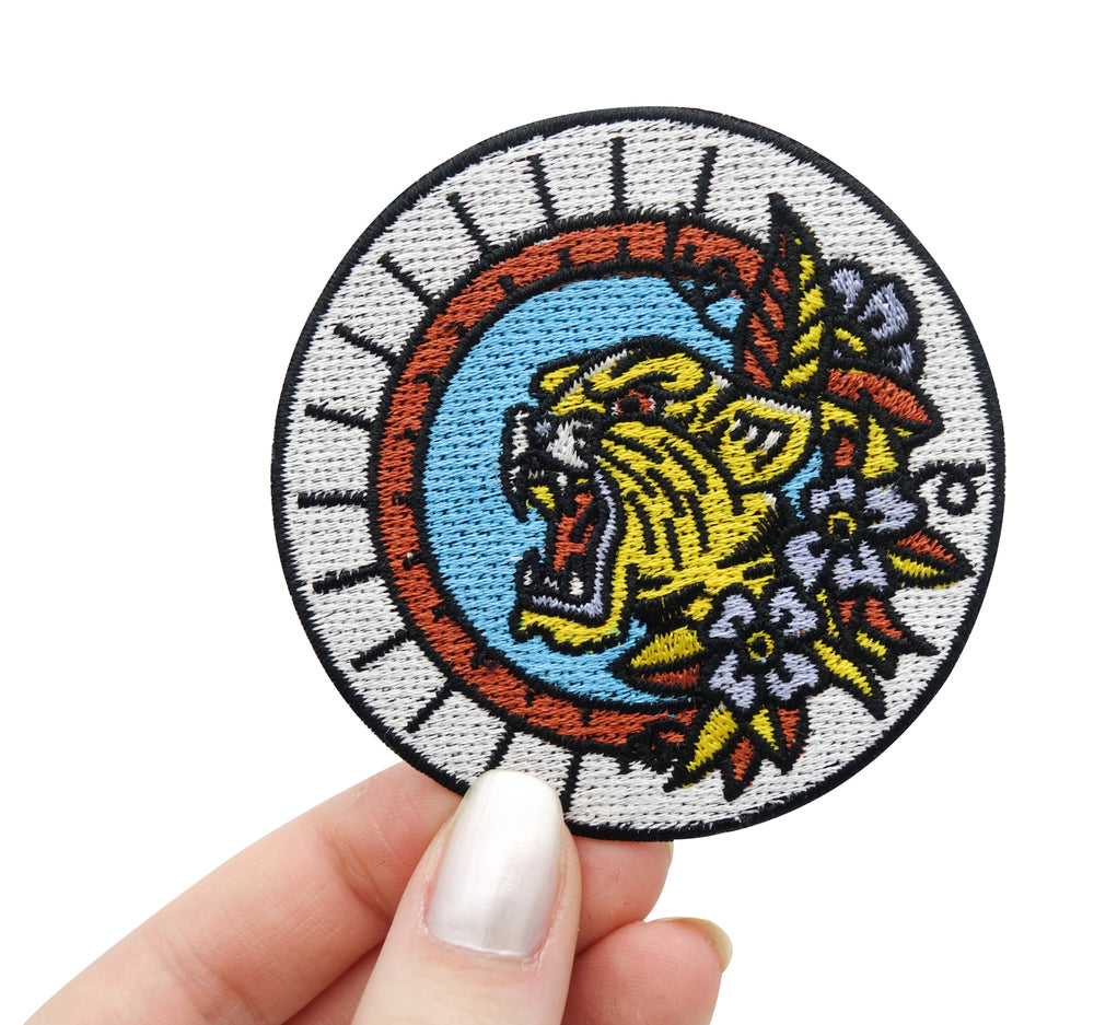 Frauenhand hält den Tiger Patch 