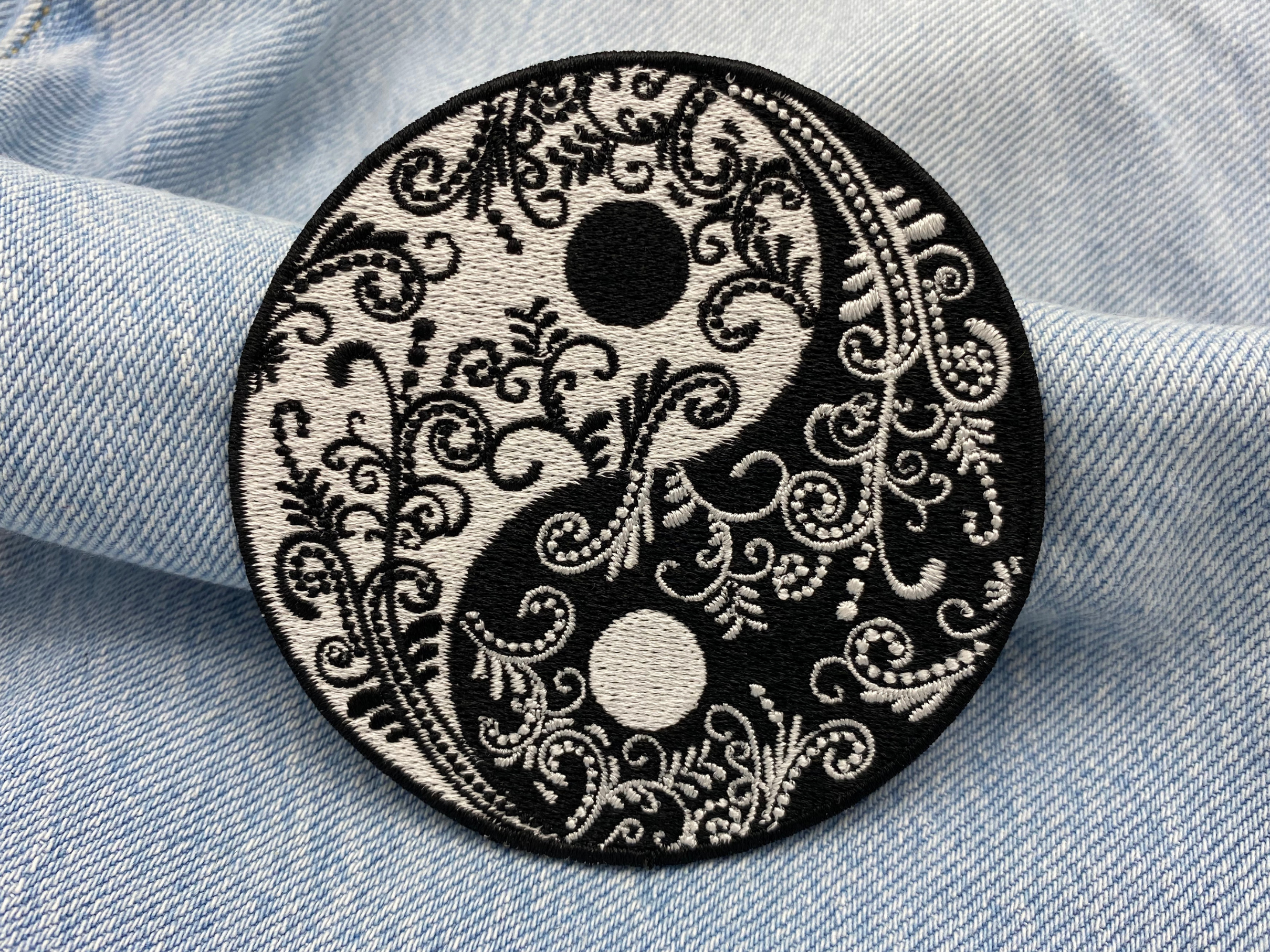 Yin und Yang Blumen Patch auf blauer Jeans