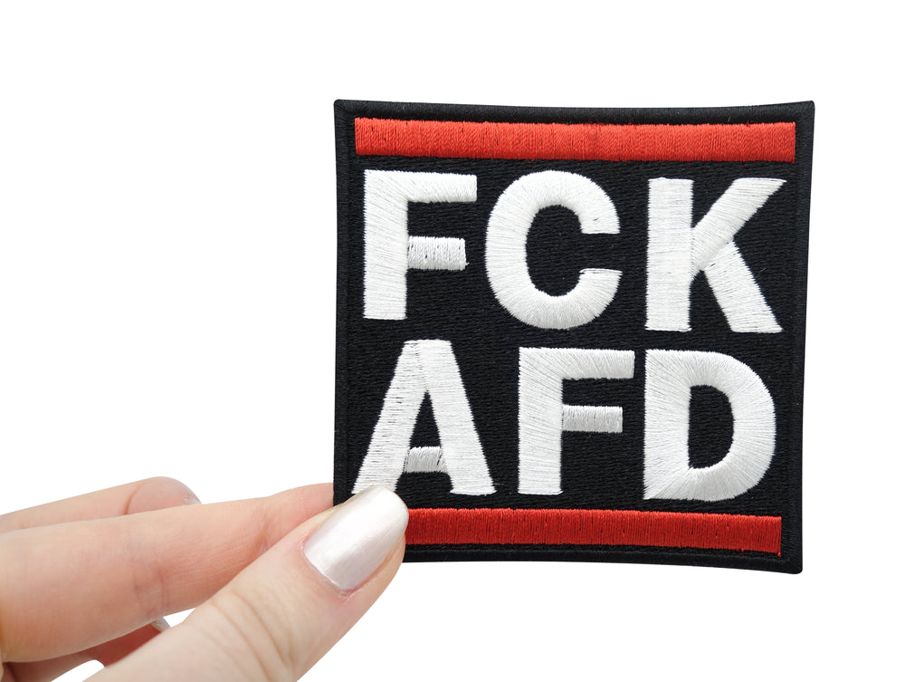 Frauenhand hält den FCK AFD Patch 
