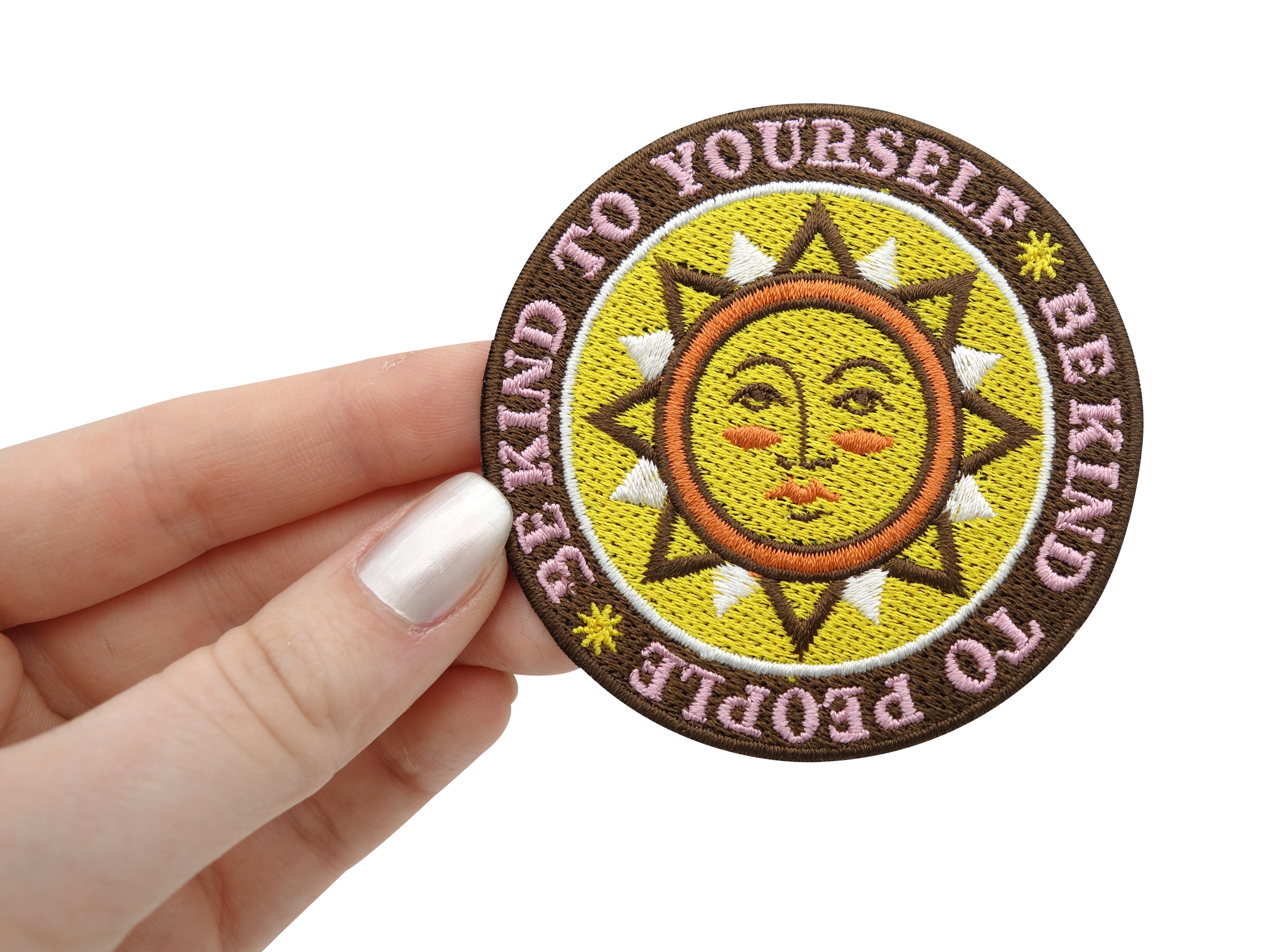 Be Kind Patch gehalten von einer Frauenhand
