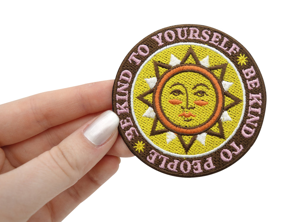 Be Kind Patch gehalten von einer Frauenhand