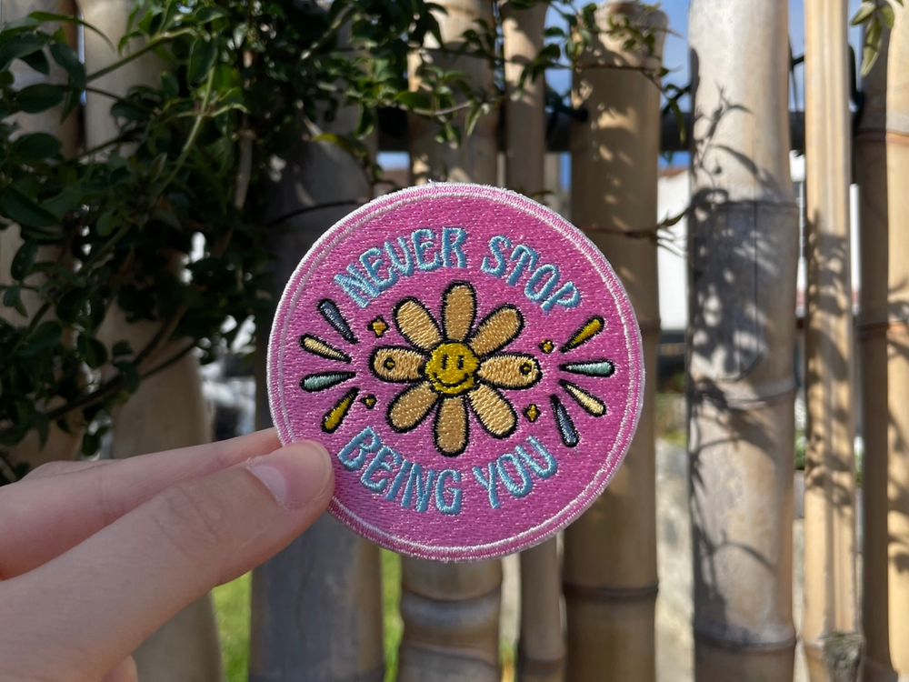 Sonnenblumen Patch gehalten von einer Frauenhand mit einem Bambuszaun im Hintergund