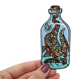 Krake in der Flasche Patch gehalten von einer Frauenhand