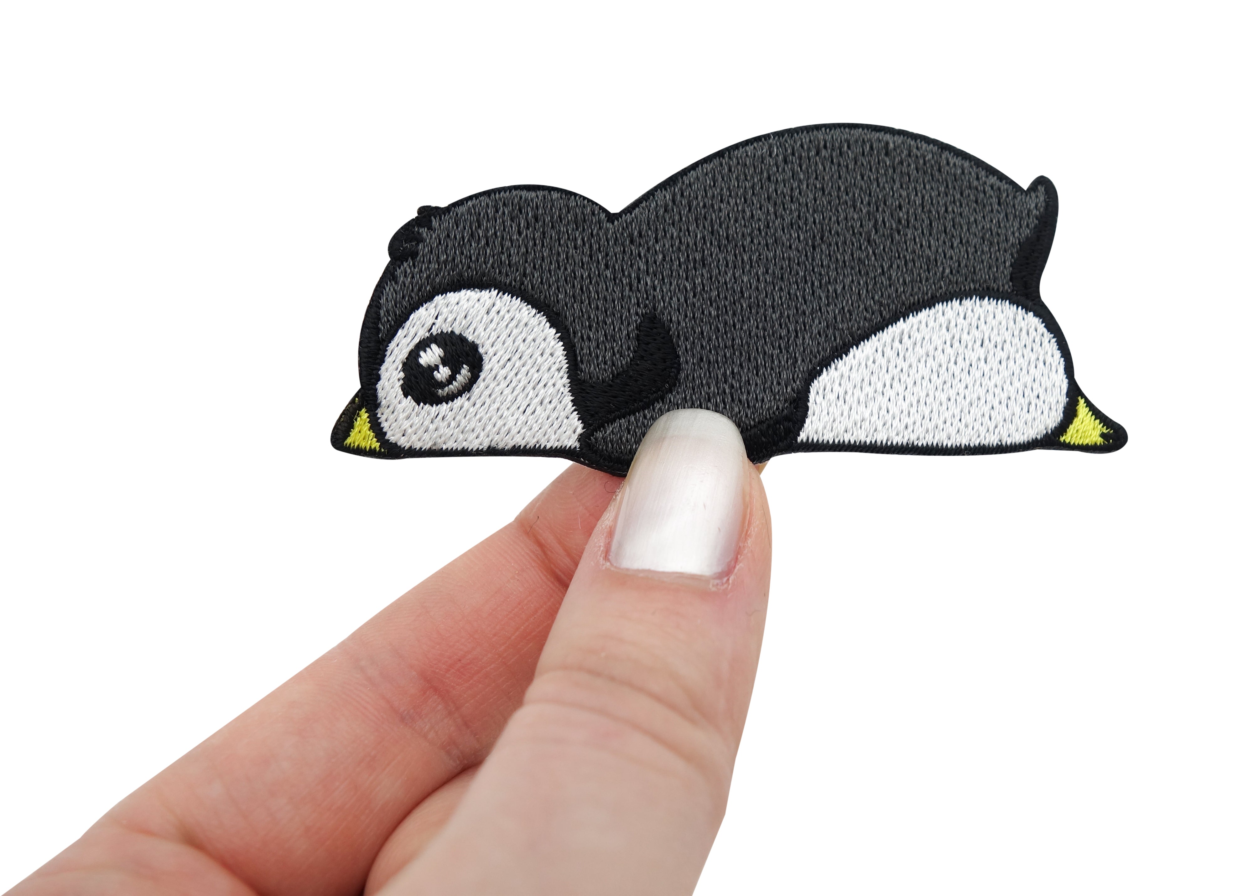 Frauenhand hält den Pinguin Patch 