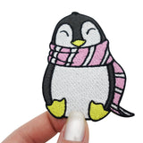 Frauenhand hält den Pinguin Patch 