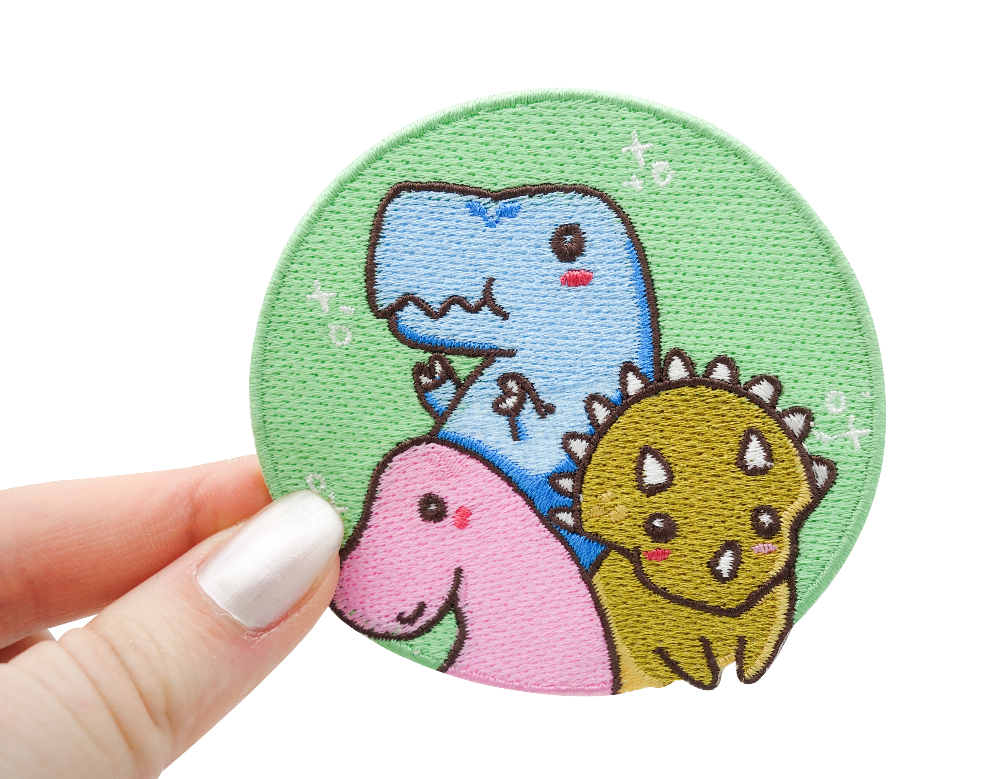 Dinosaurier Patch gehalten von einer Frauenhand