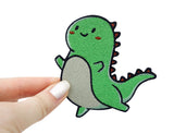 Frauenhand hält den T-Rex Patch 