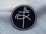 Kreuz & Fisch Patch auf blauer Jeans
