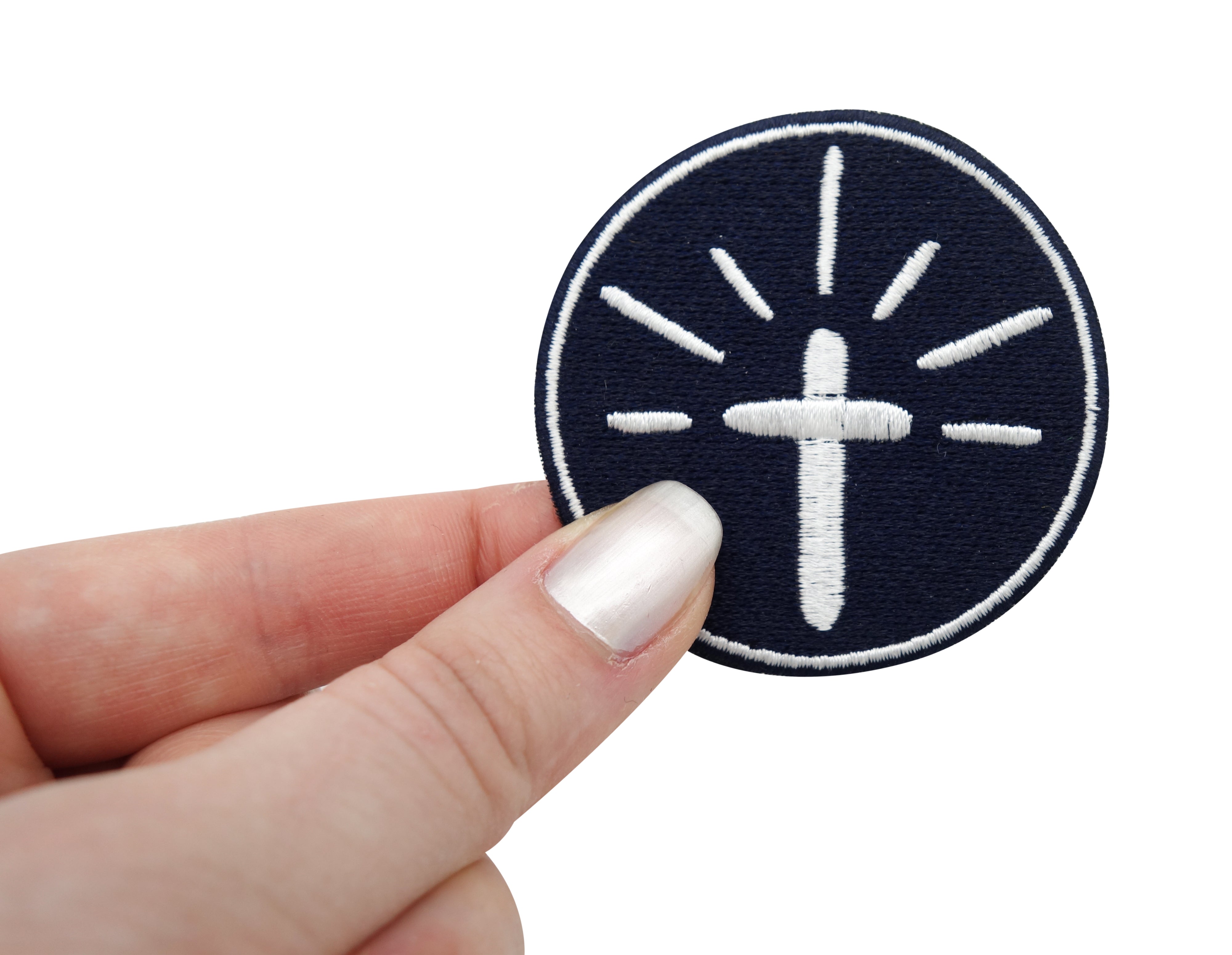 Frauenhand hält den Kreuz Patch