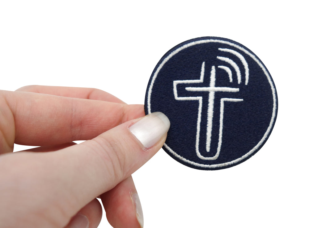 Frauenhand hält den Kreuz Patch