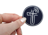 Frauenhand hält den Kreuz Patch