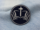 Bibel mit Kreuz Patch auf blauer Jeans