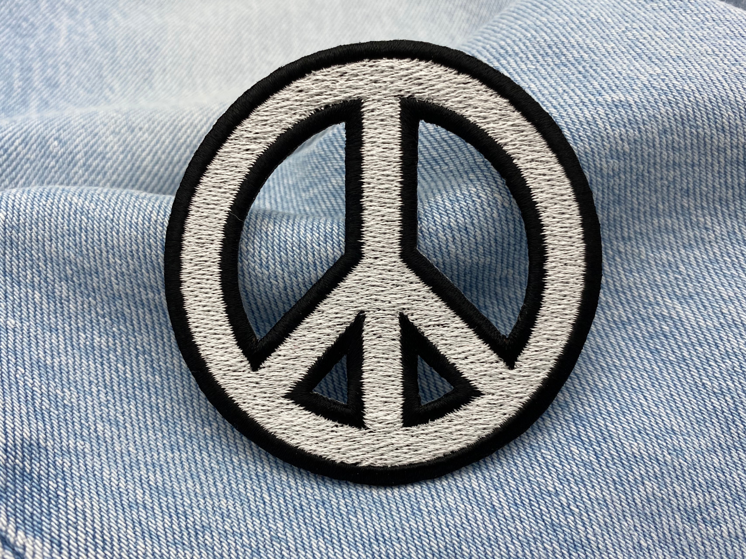 Peace Zeichen Patch auf blauer Jeans