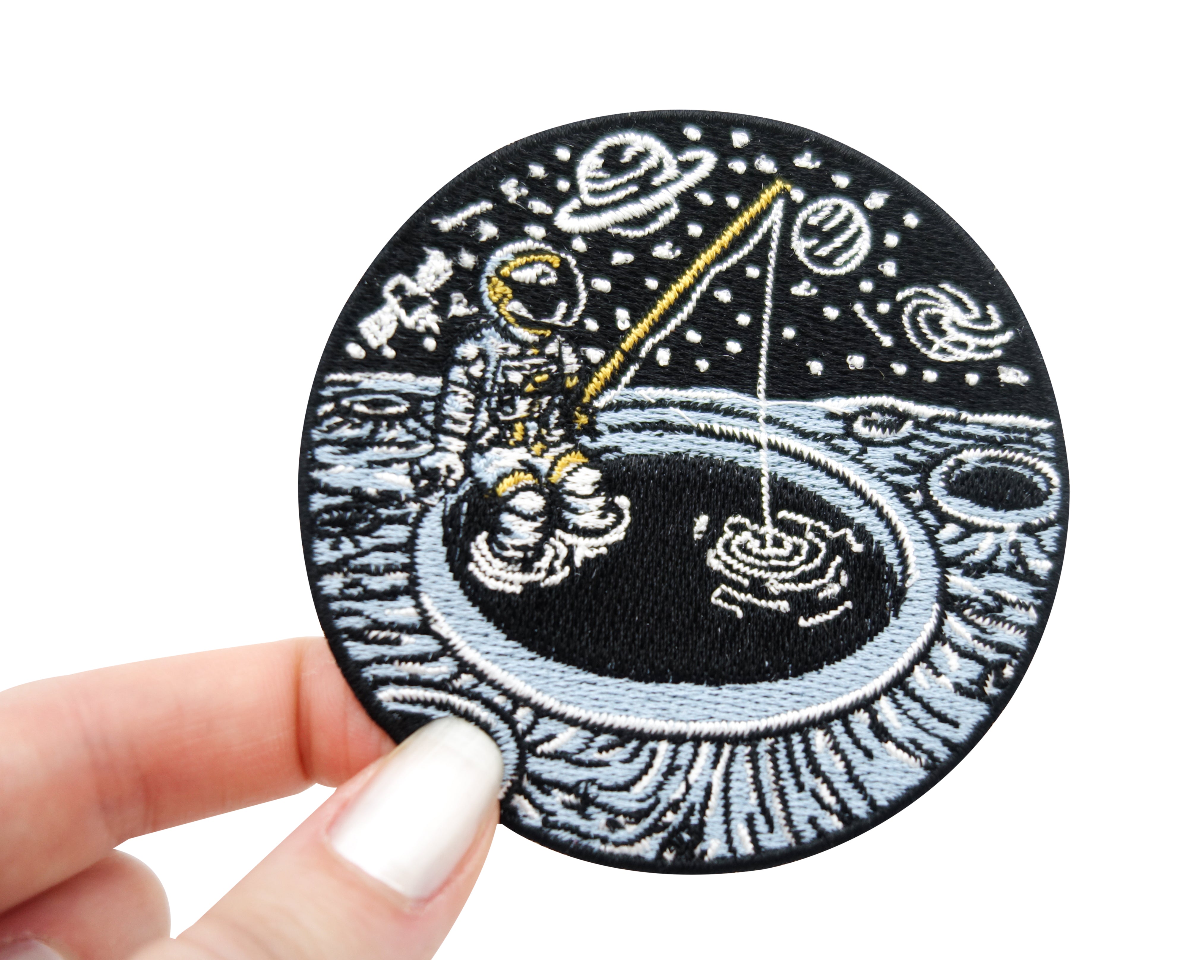 Frauenhand hält den angelnden Astronauten Patch 