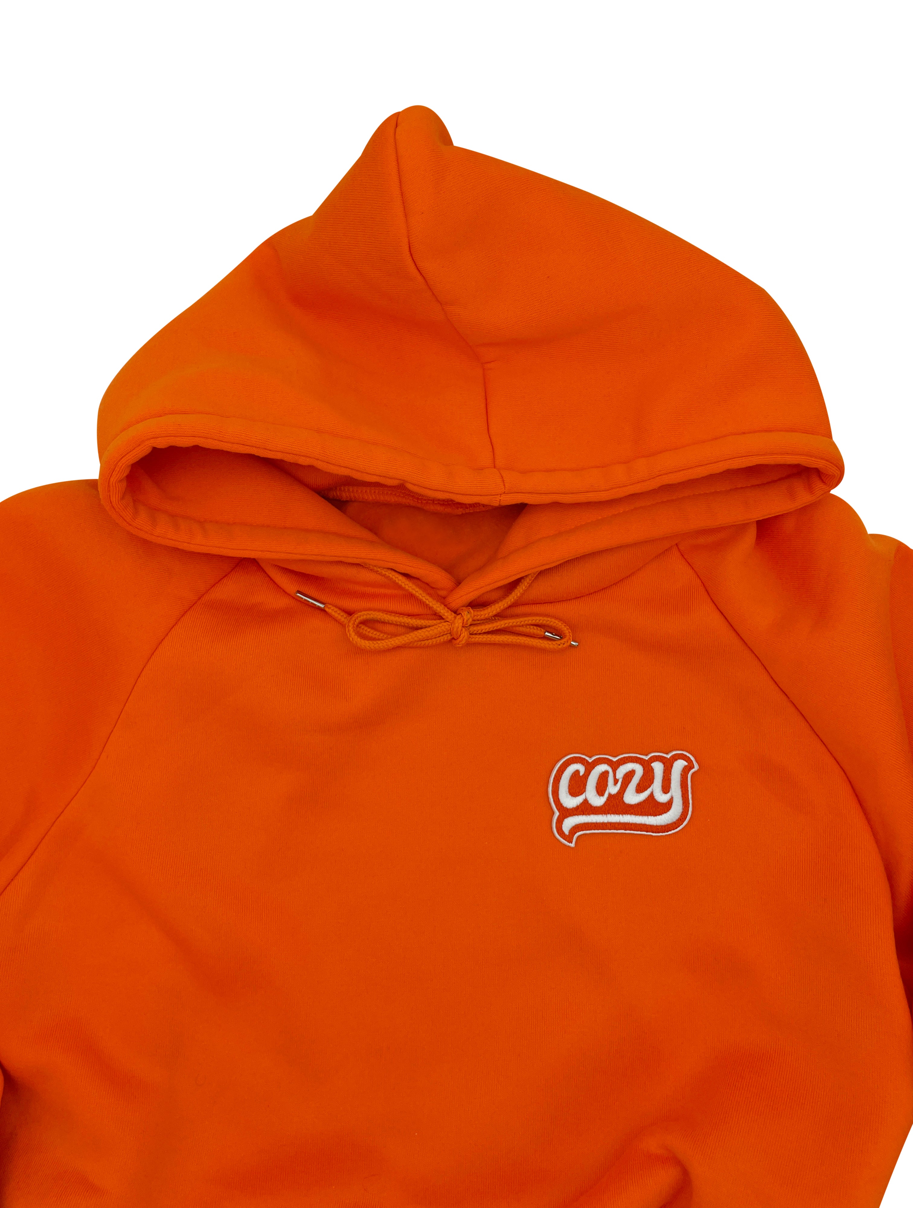 Cozy Patch auf orangenem Pullover aufgebügelt