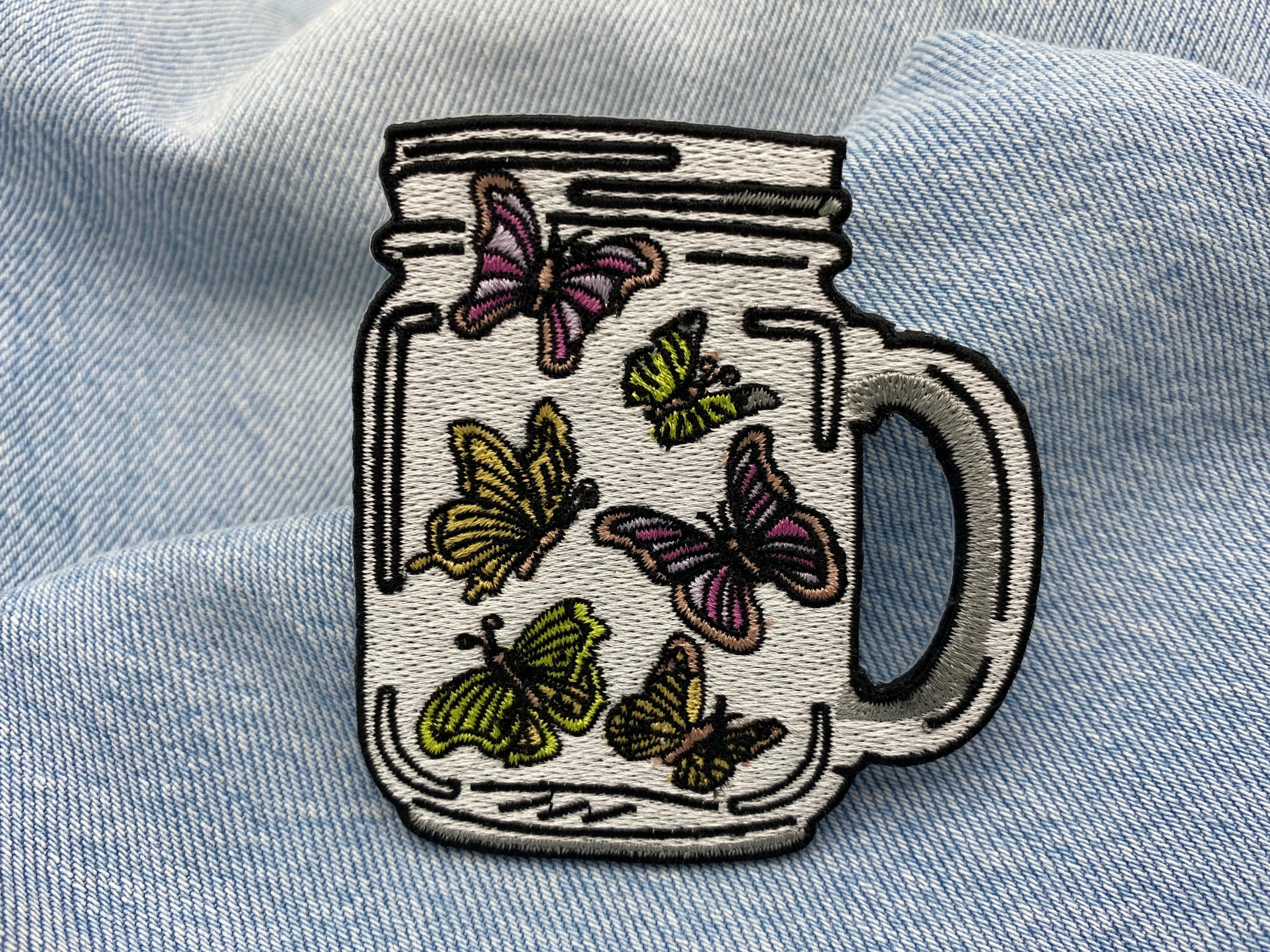 Schmetterlinge im Glas Patch auf blauer Jeans