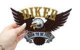 Frauenhand hält den Adler Patch