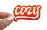 Cozy Patch gehalten von einer Frauenhand