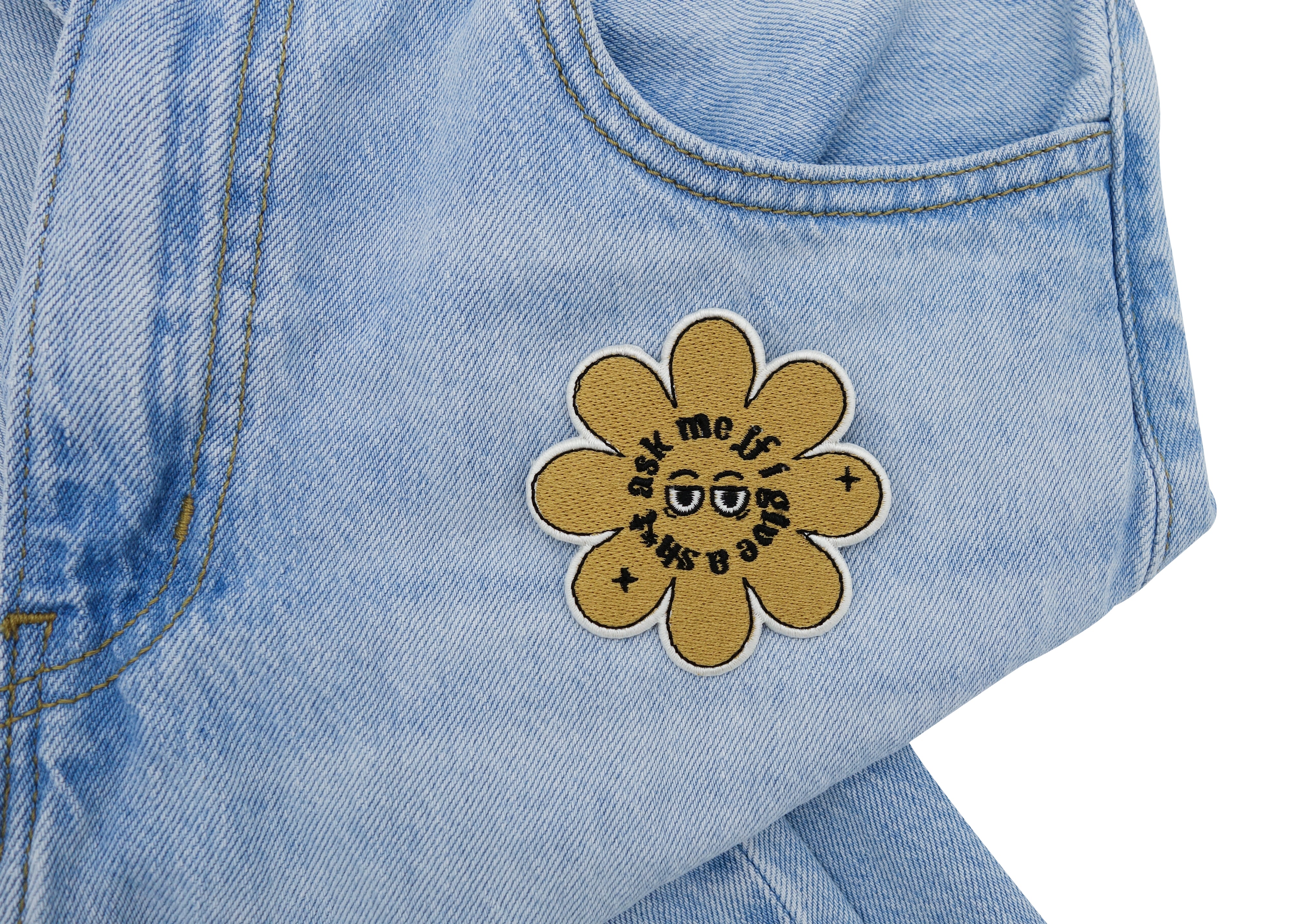 Blumen Patch auf heller blauer Jeans aufgebügelt