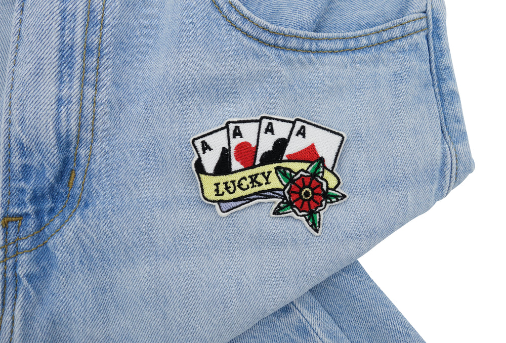 Lucky Karten Patch auf heller blauer Jeans aufgebügelt