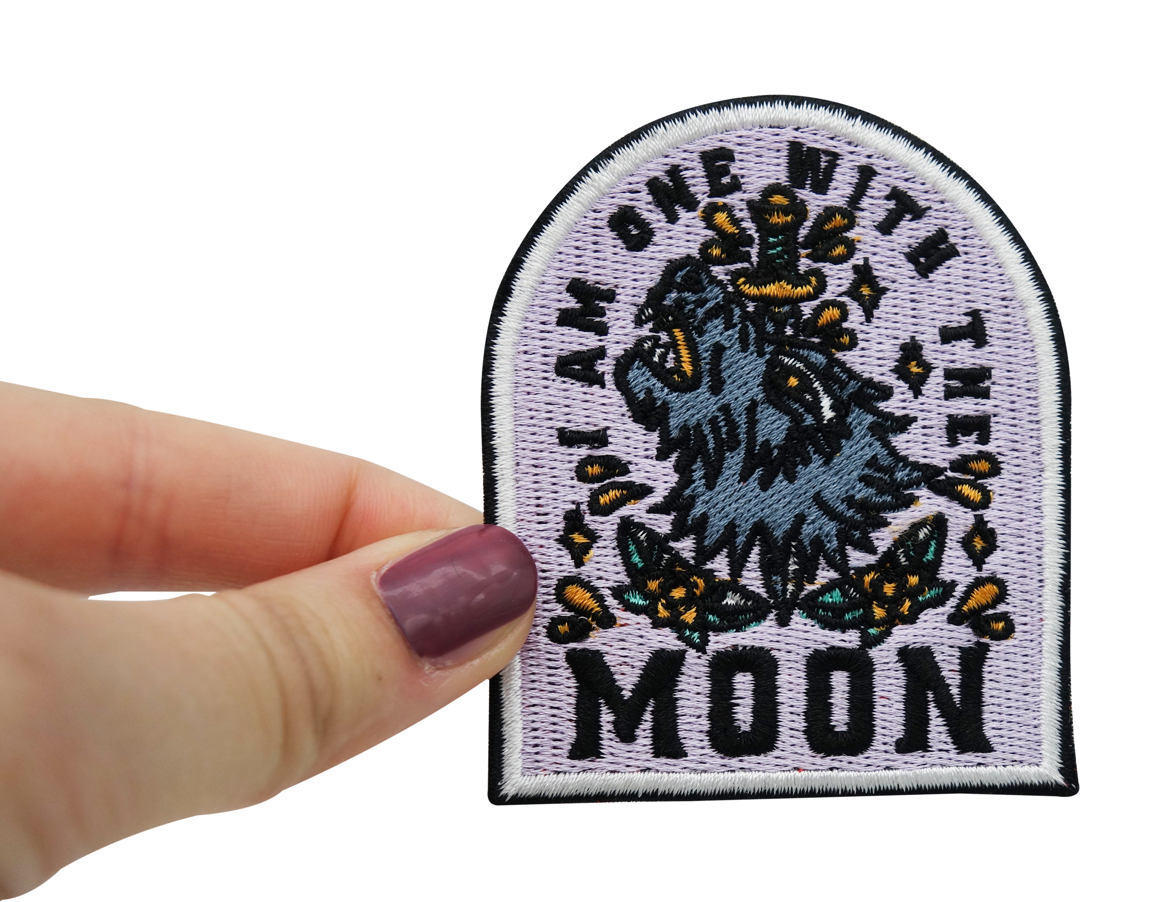 Frauenhand hält den Wolf Patch