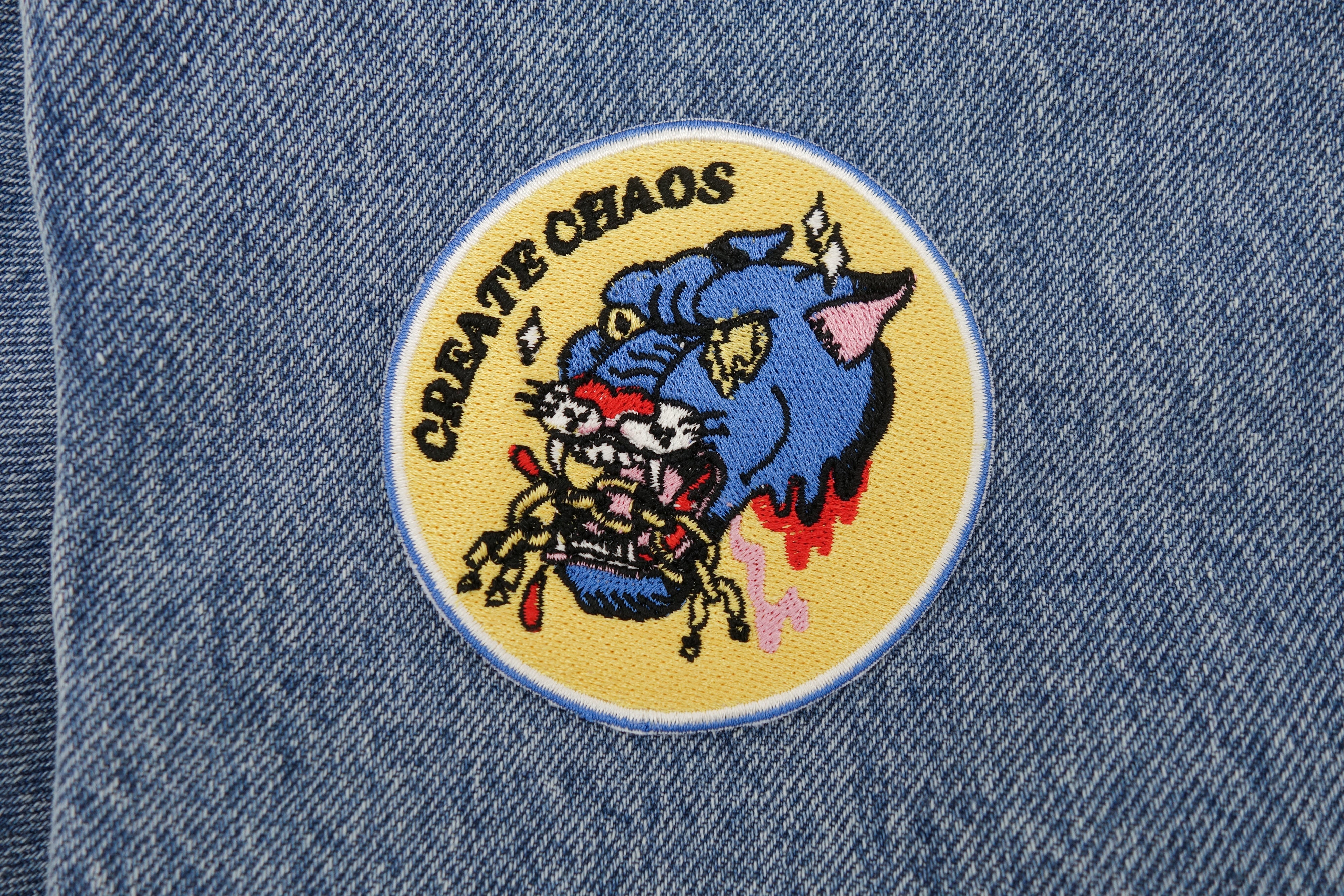 Chaos Patch auf blauer Jeans