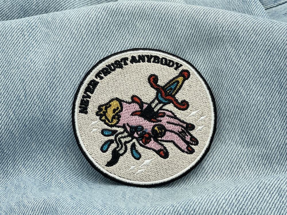 Never Trust Anybody Patch auf heller blauer Jeans