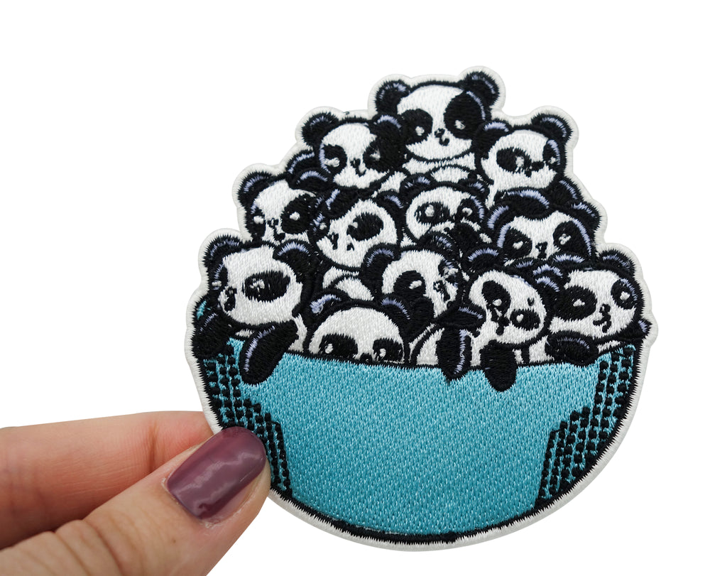 Frauenhand hält den Pandabären Patch 
