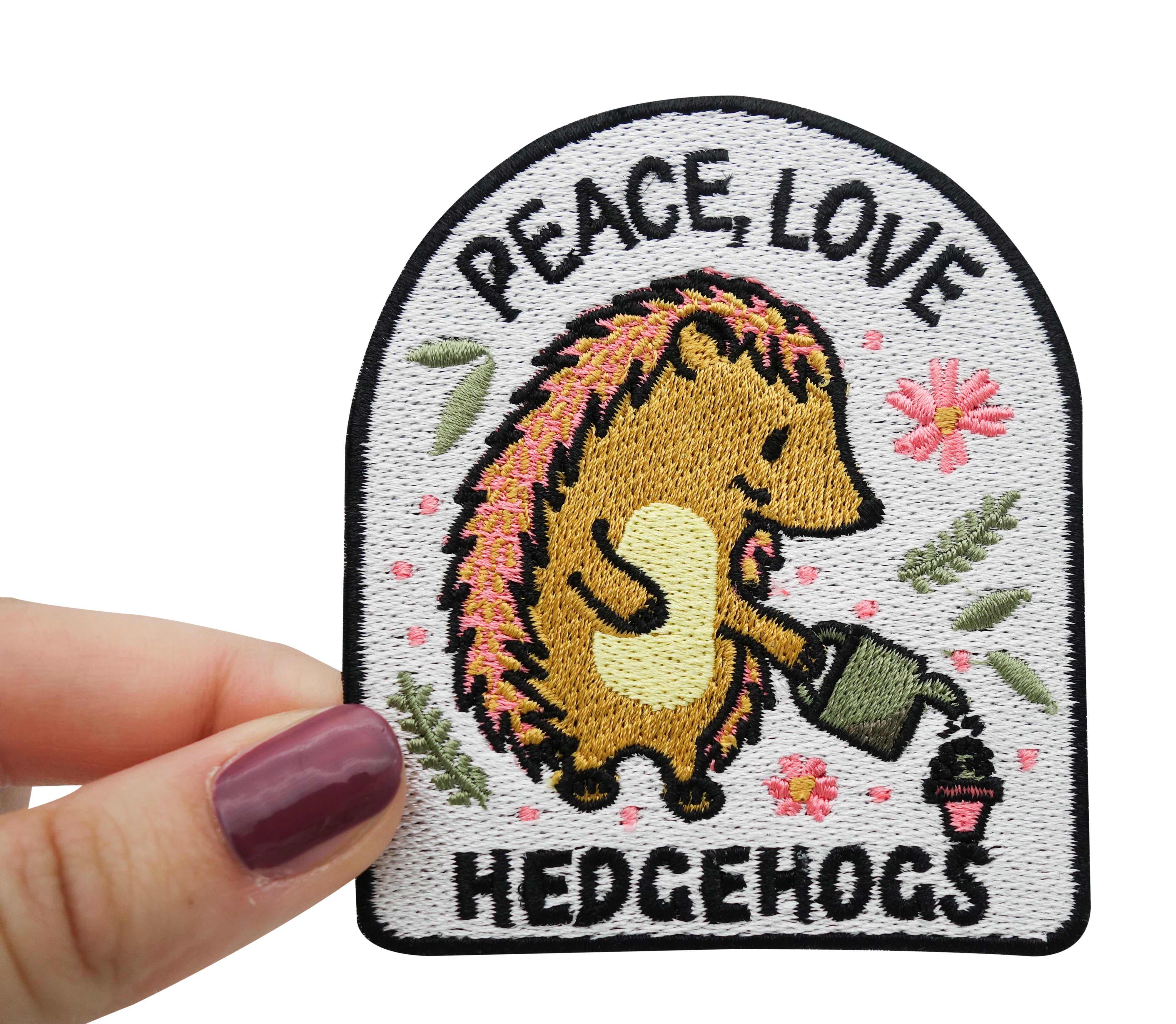 Frauenhand hält den Igel Patch