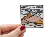 Frauenhand hält den Berglandschaft Patch