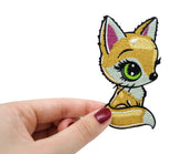 Frauenhand hält den Baby Fuchs Patch