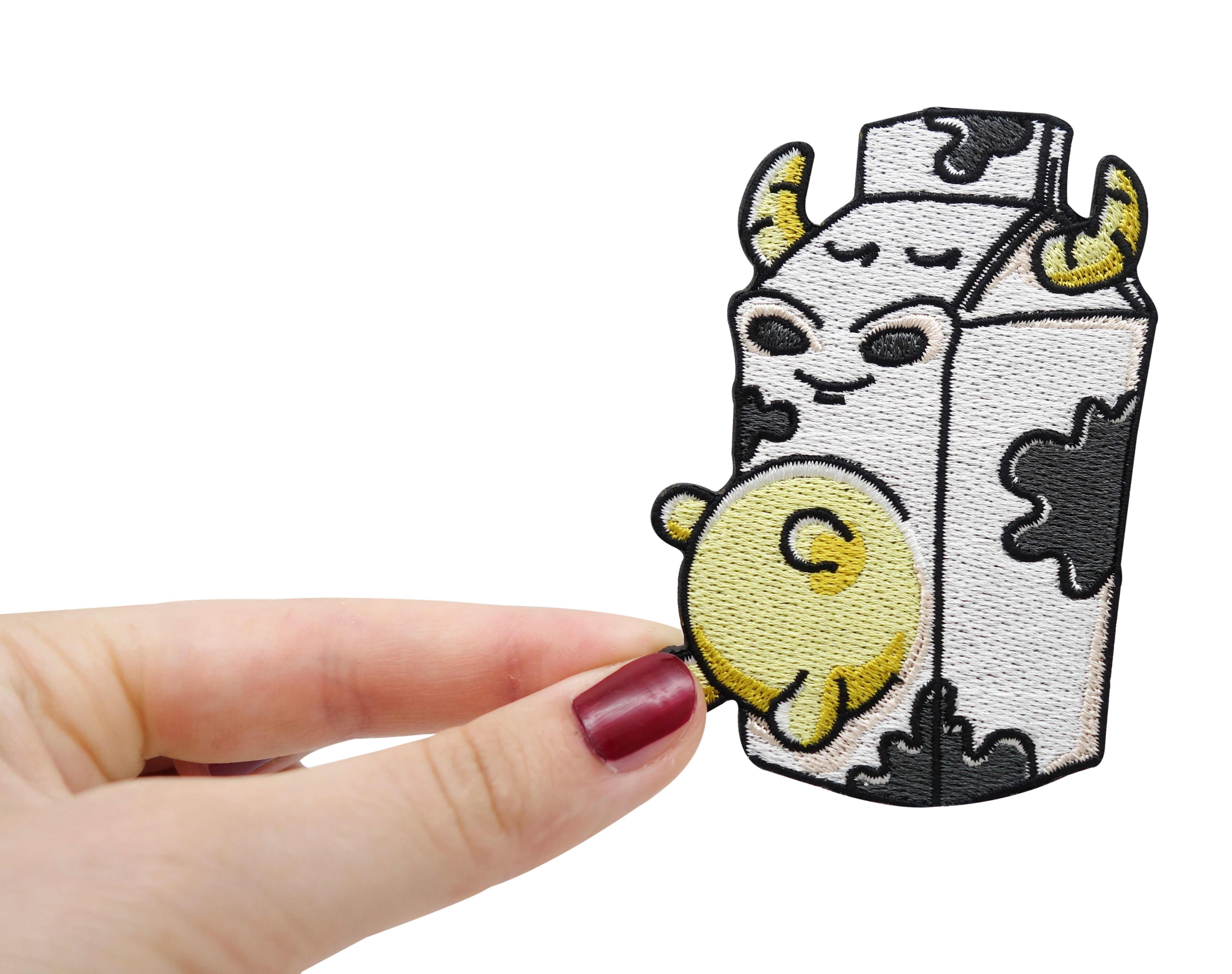 Frauenhand hält den Milch Kuh Patch