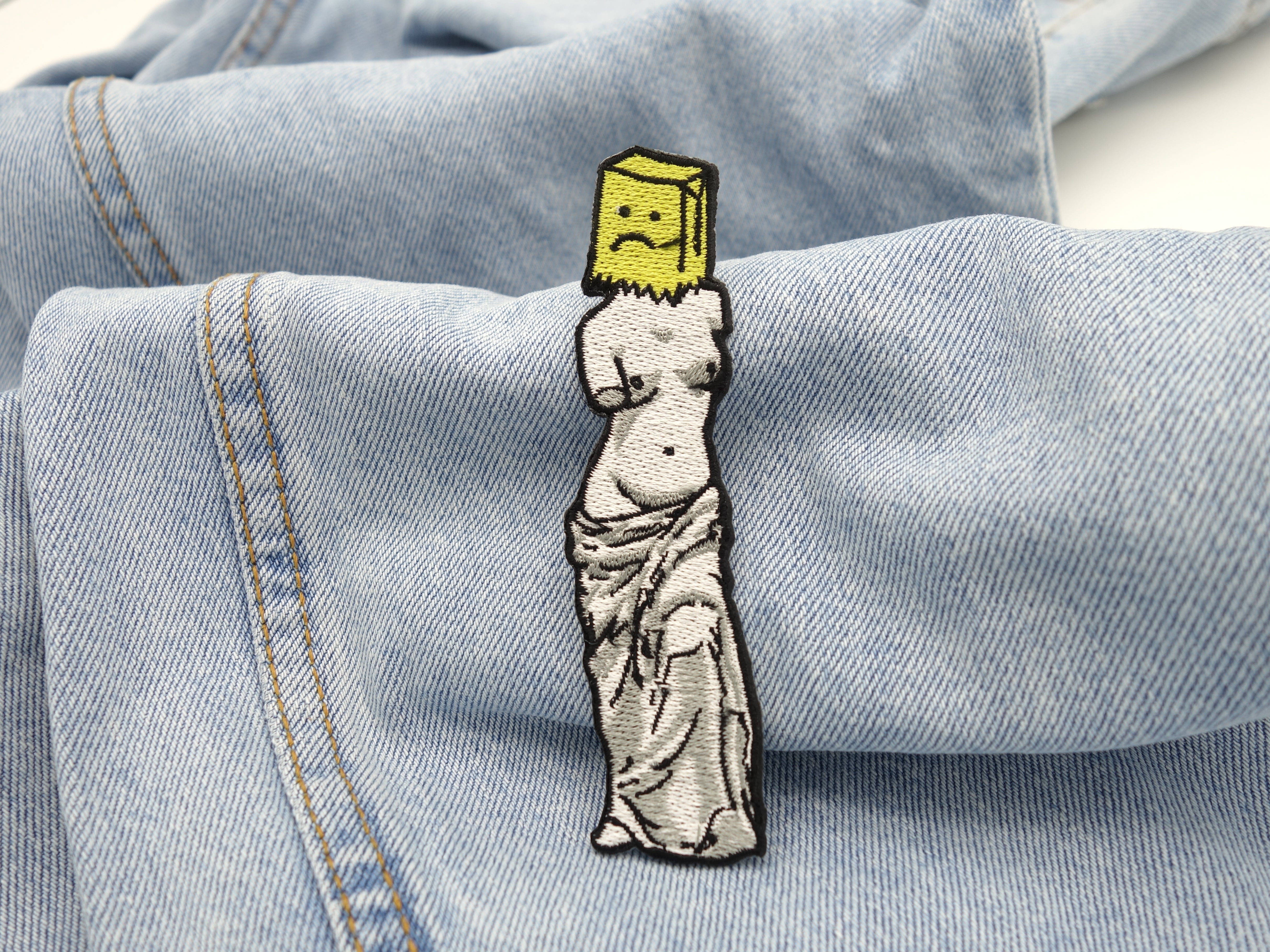 Statue Patch auf hellblauer Jeans