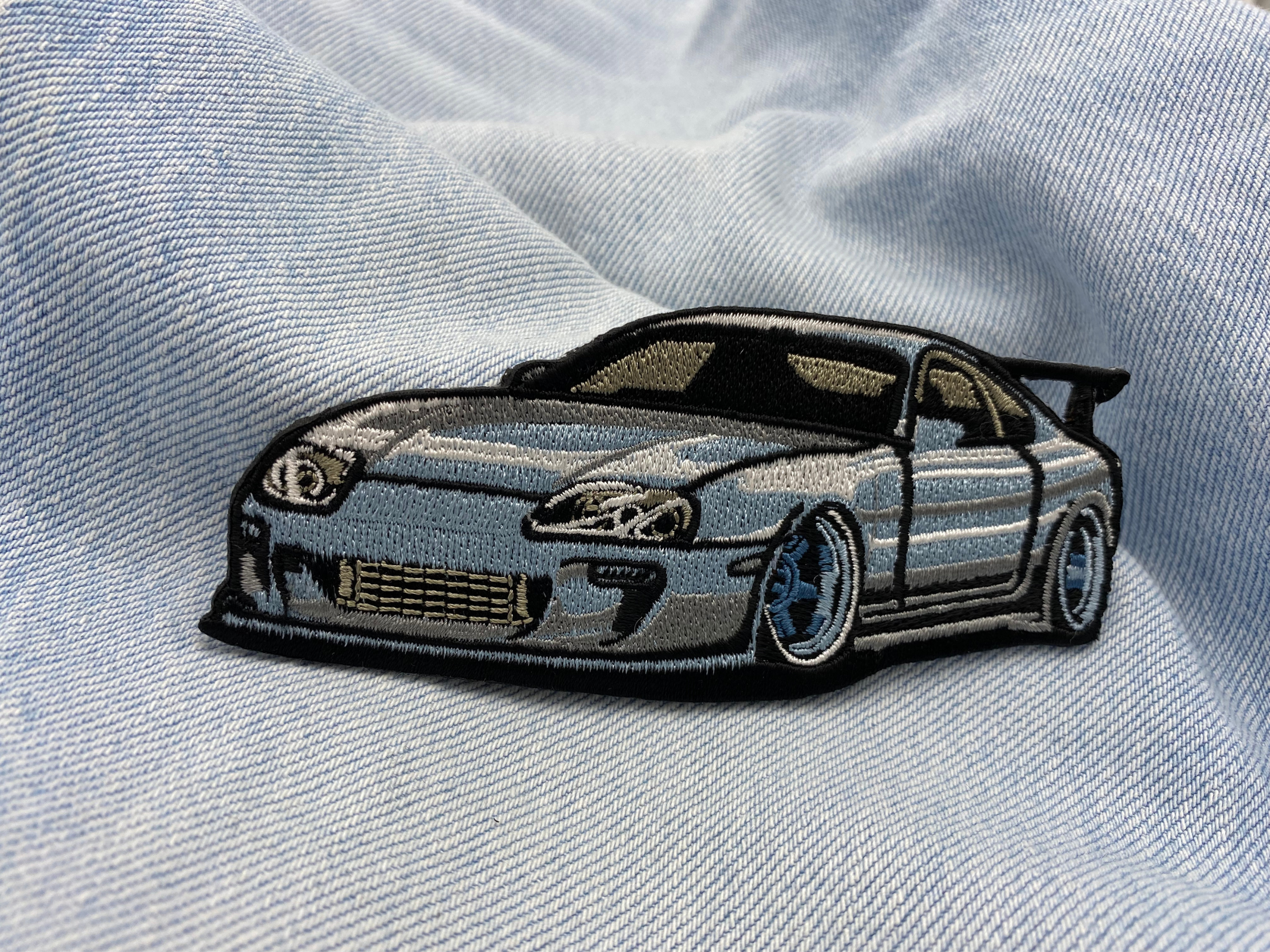 Sportwagen Patch auf hellblauer Jeans